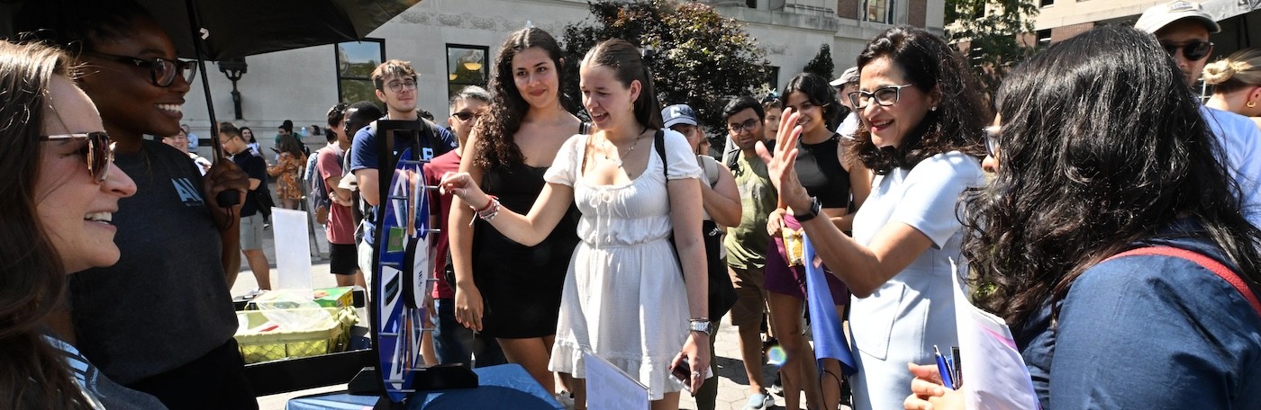 Students and staff greet President Shafik at a campus activities fair at Columbia